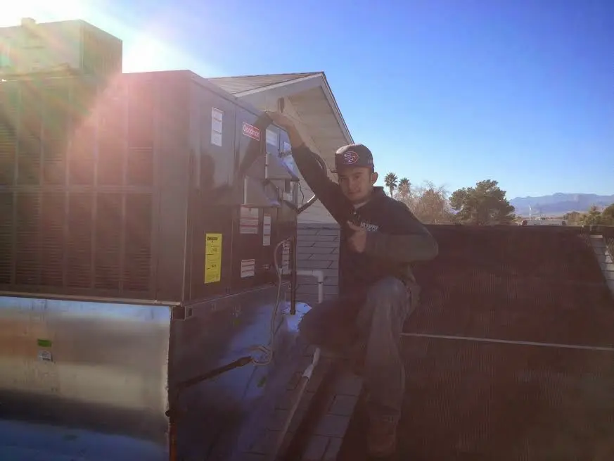 HVAC technician performing Heat Pump Repair on a rooftop unit in Santa Cruz